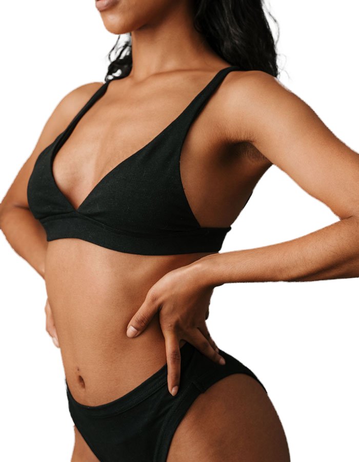 Woman in black swimwear with hand on hip showing a smooth hip curve, alloClae hip dip treatment