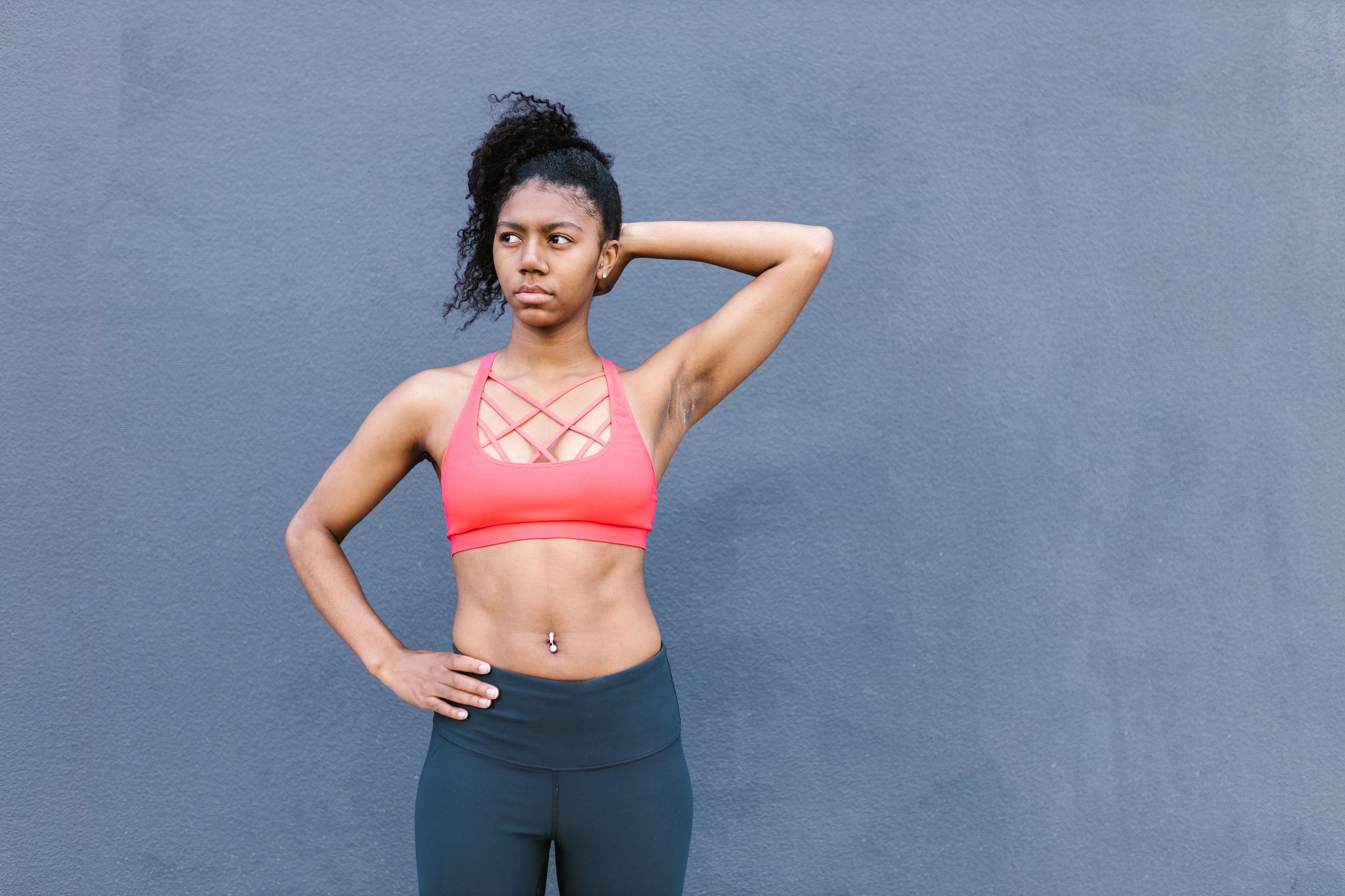 Confident woman in athletic wear posing outdoors, representing strength and body confidence after fitness-focused contouring